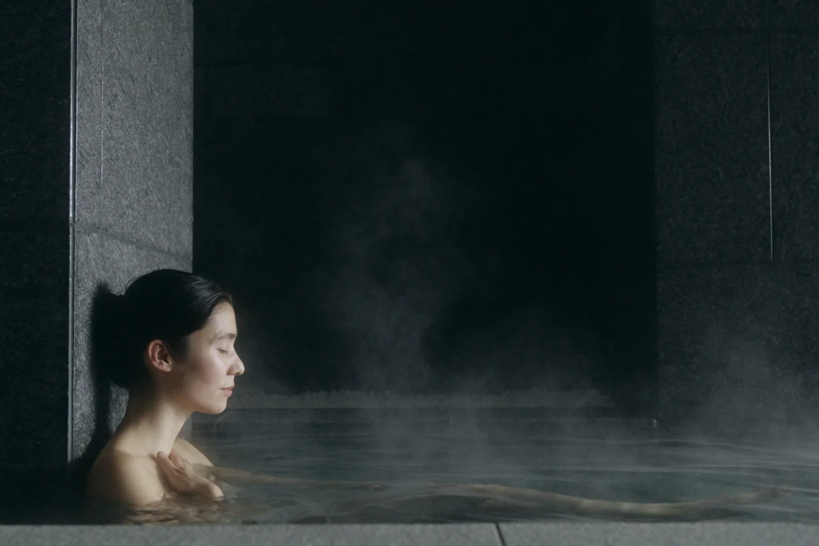 Woman in a steaming onsen bath